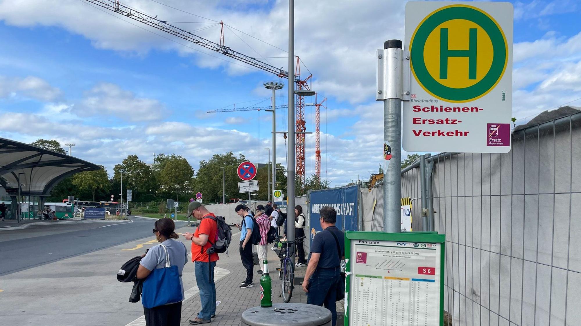 Menschen an der Haltestelle für Schienenersatzverkehr.