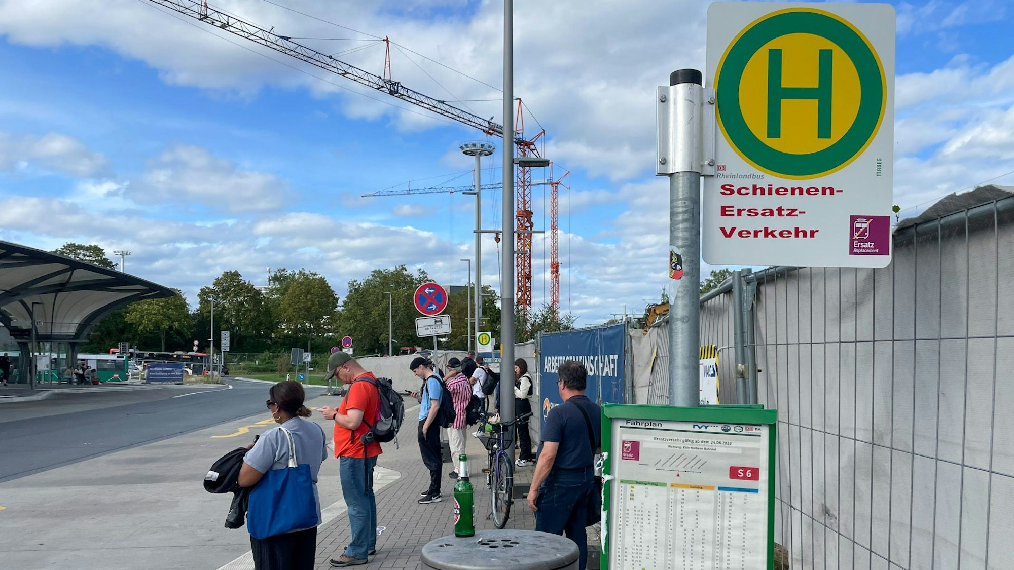 Menschen an der Haltestelle für Schienenersatzverkehr.