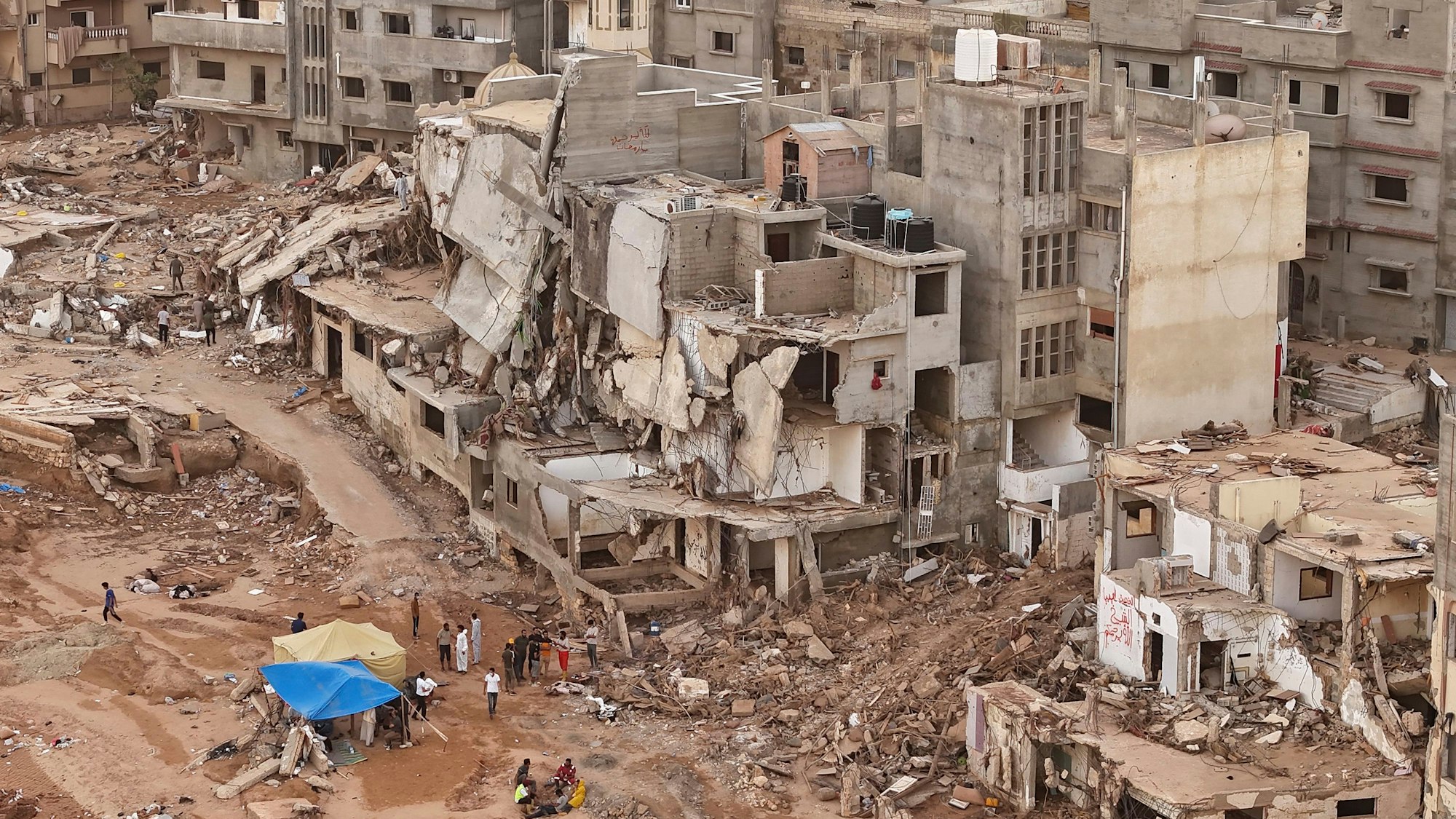 Libyen, Darna: Retter und Angehörige von Opfern errichten Zelte vor eingestürzten Gebäuden.