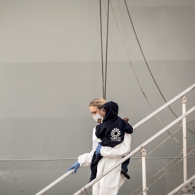 Ein Kleinkind wird im Hafen von Salerno (Italien) von einer Rettungskraft vom Schiff getragen. (Symbolbild)