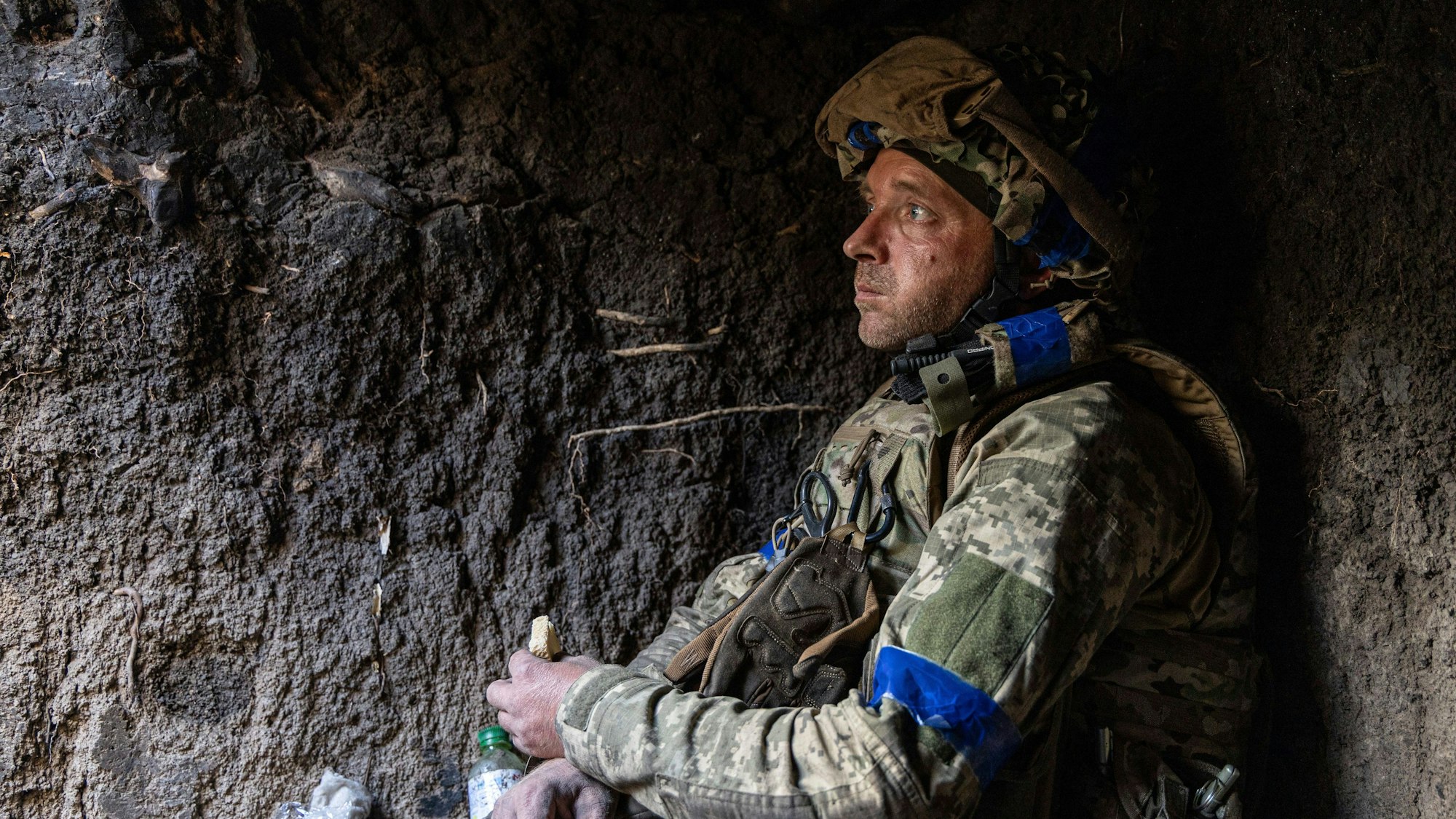Ein ukrainischer Soldat isst in seiner Stellung in der Nähe der Frontlinie bei Bachmut ein Stück Brot.
