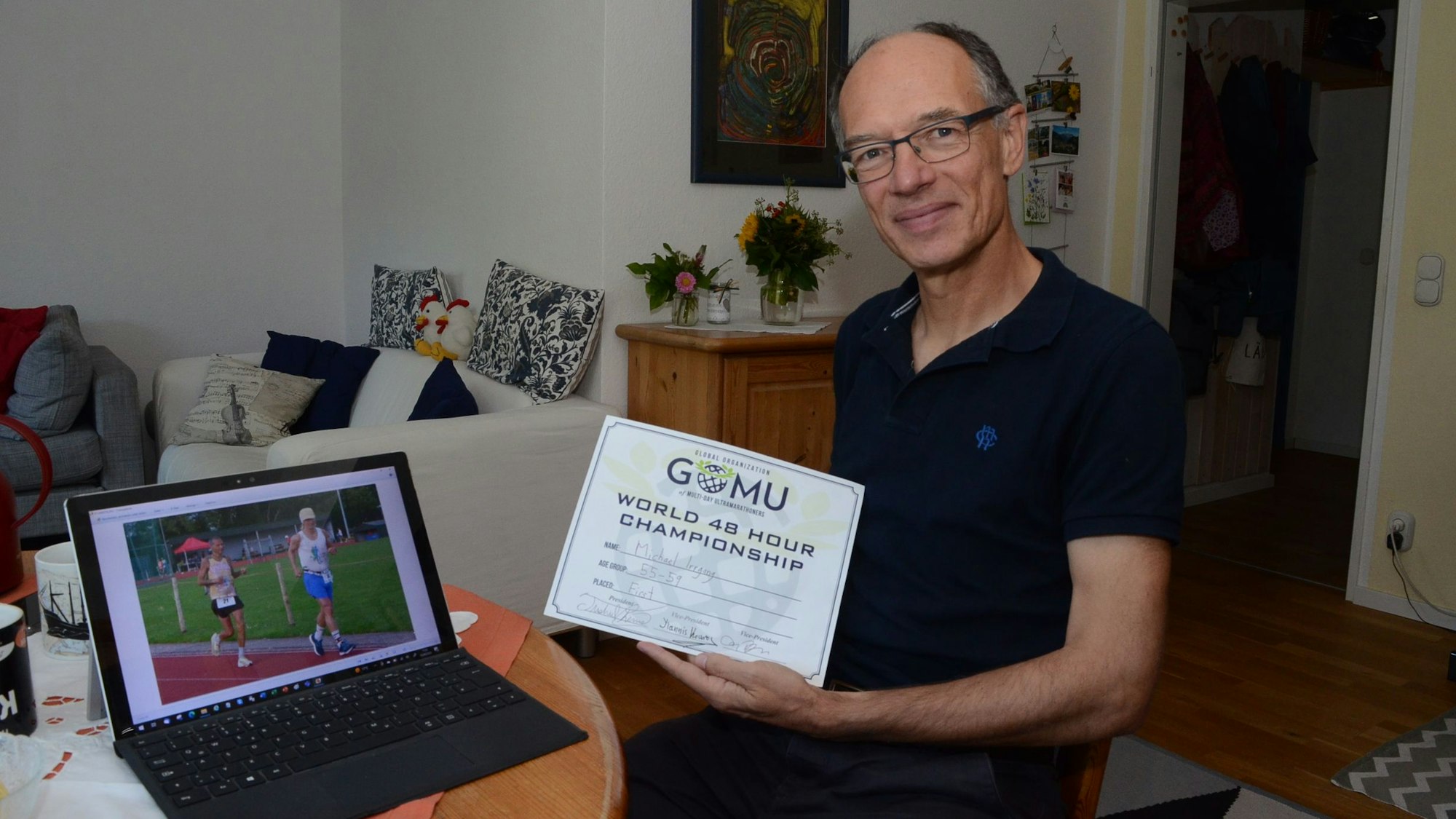 Ein Mann zeigt eine Urkunde in die Kamera.