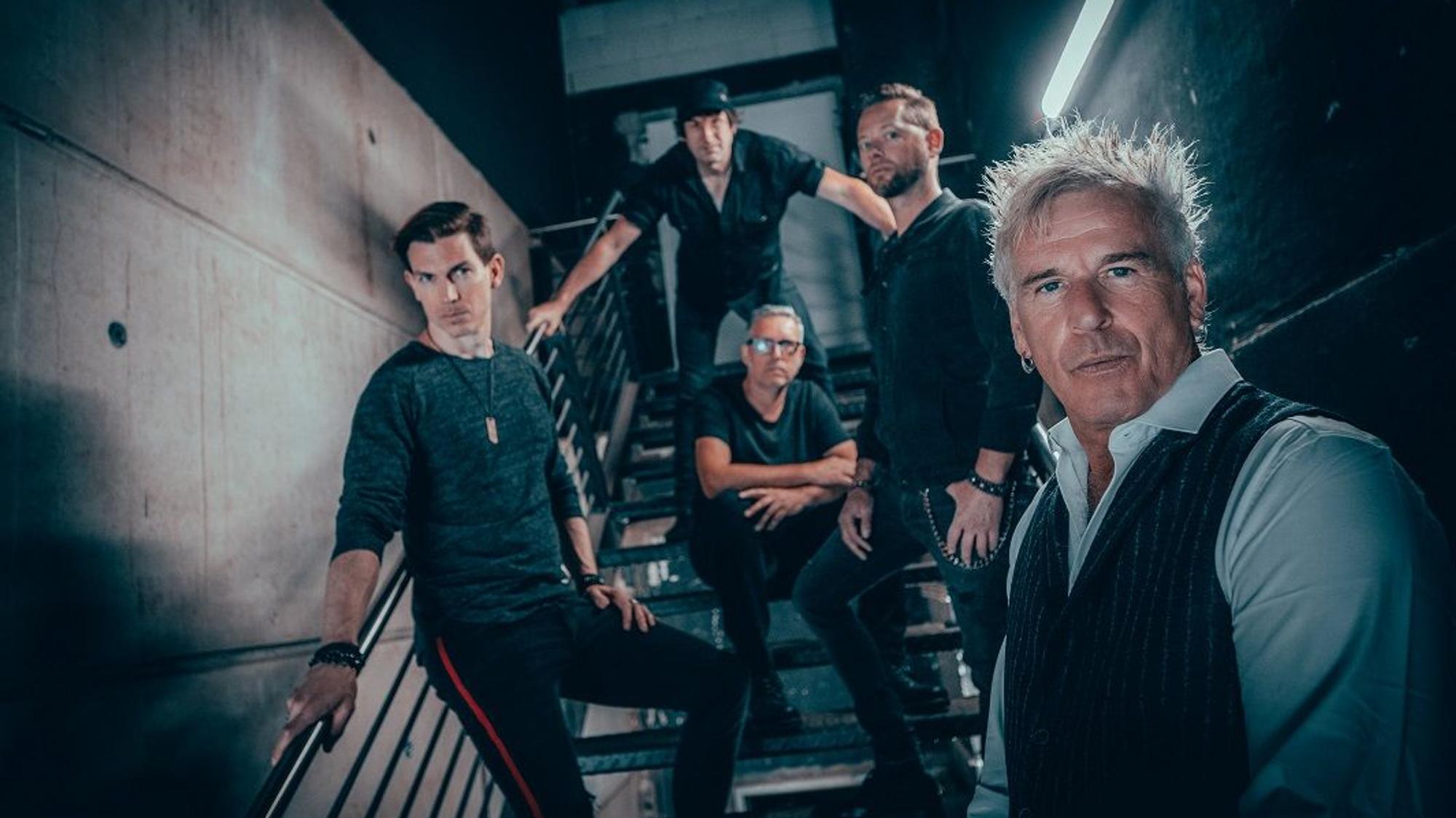 Die Musiker der Gruppe Universum 25 posieren auf einer Treppe.