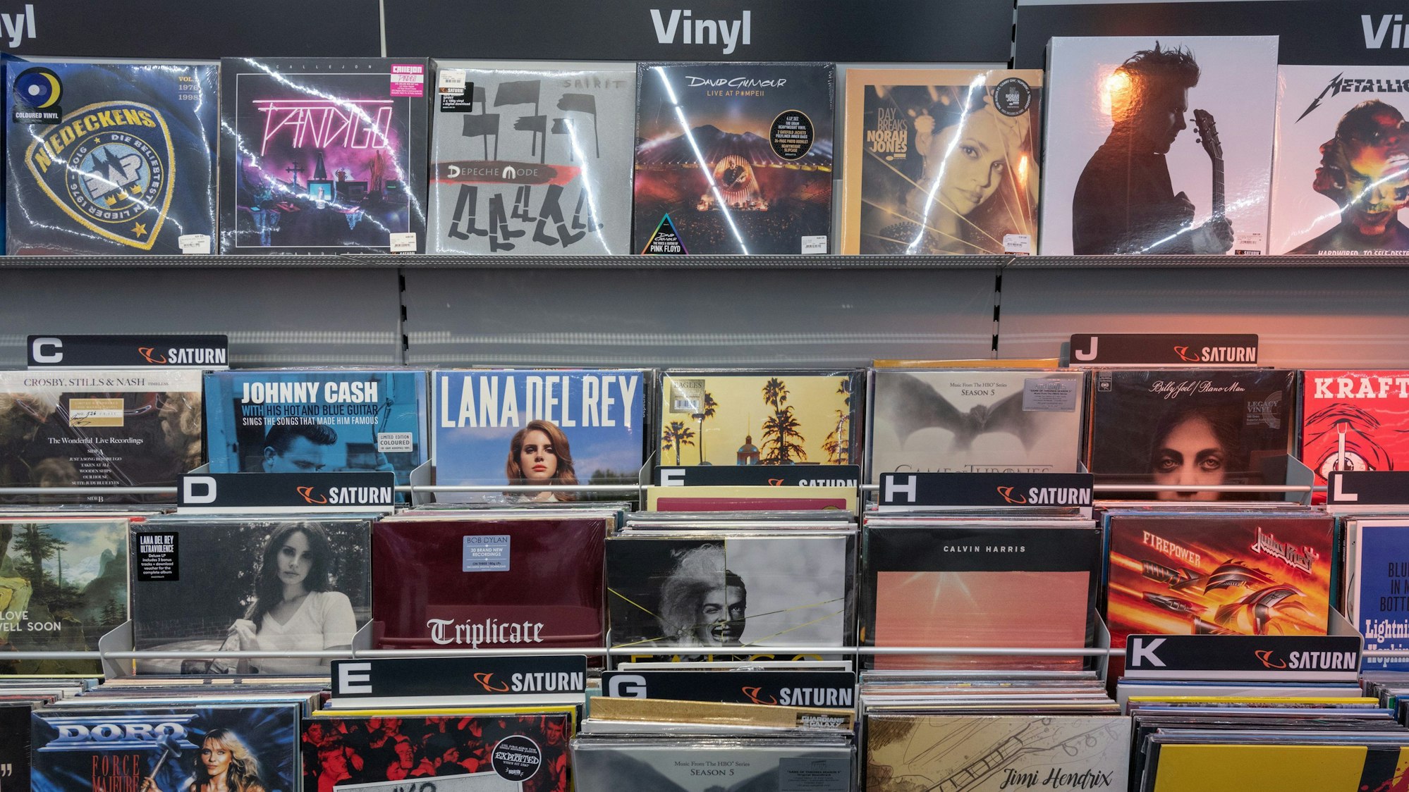 Ein Regal mit Schallplatten steht in einem Elektronikmarkt. Musikfans in Deutschland kaufen immer häufiger digital ein, vergessen aber auch die gute alte Vinylplatte nicht.