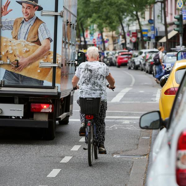 An der Neusser Straße in Nippes herrscht dichter Verkehr. Autos parken dicht an dicht am Straßenrand.