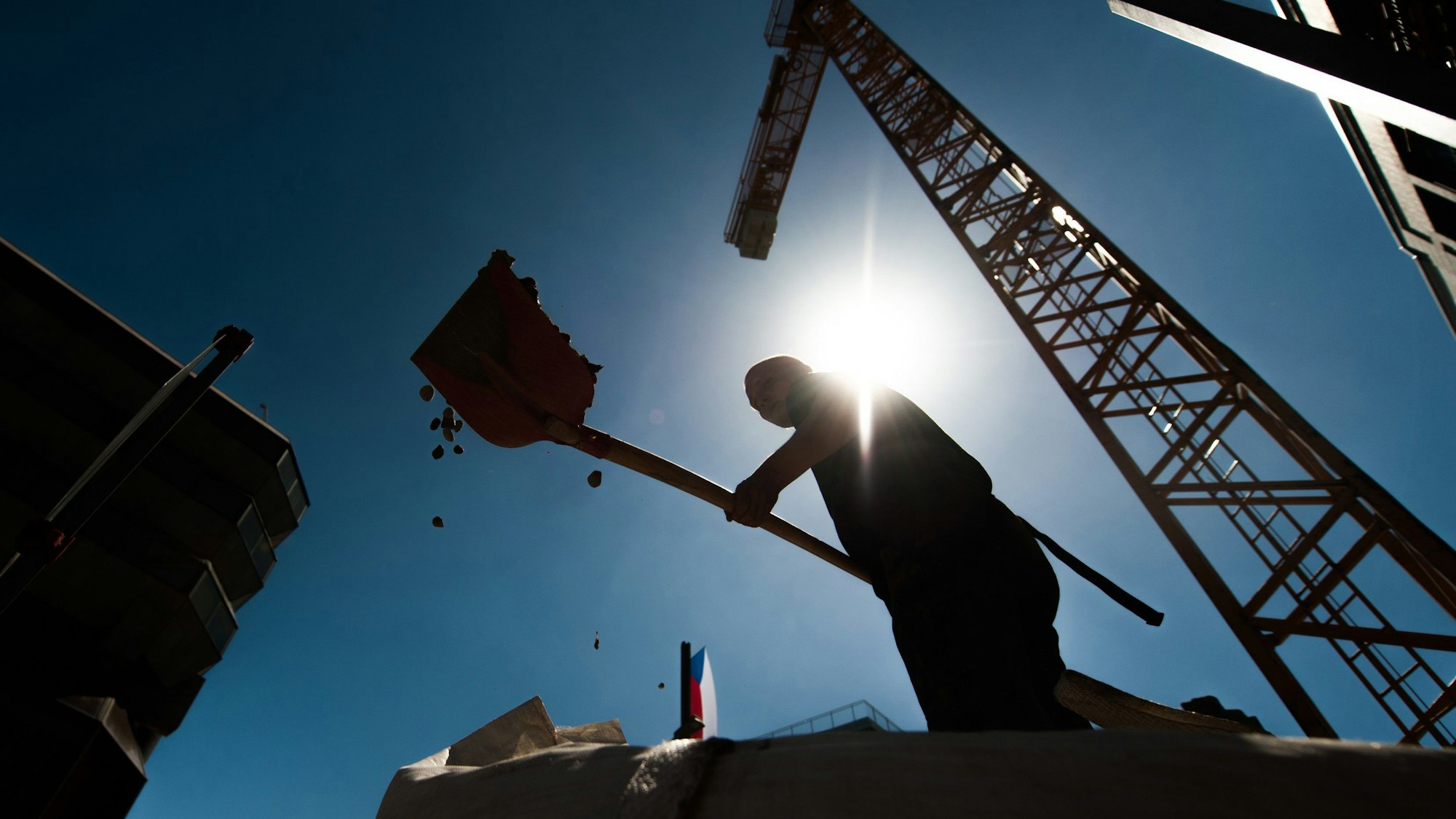 Ein Bauarbeiter arbeitet mit einer Schaufel. Vor dem Hintergrund schwacher Wachstumszahlen und einer trüben Stimmung bei vielen Unternehmern und Verbrauchern hat die Industriestaatenorganisation OECD am Dienstag ihren Konjunkturausblick vorgelegt. (Archivbild)