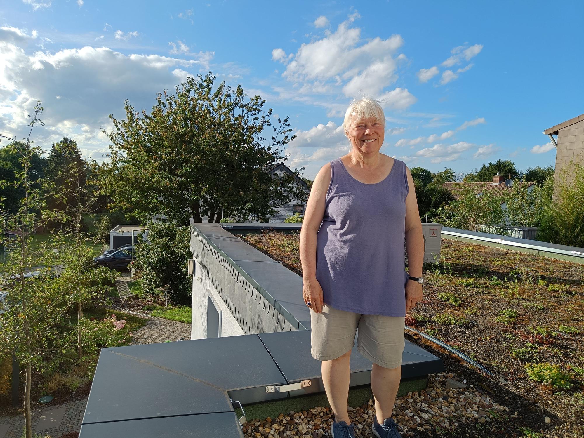 Eine Frau steht auf einem begrünten Dach.