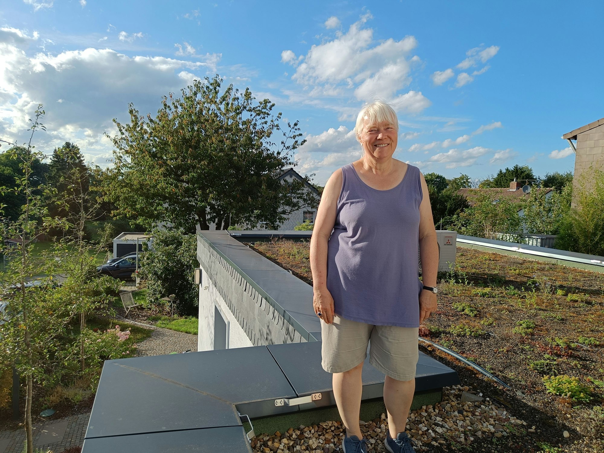 Eine Frau steht auf einem begrünten Dach.