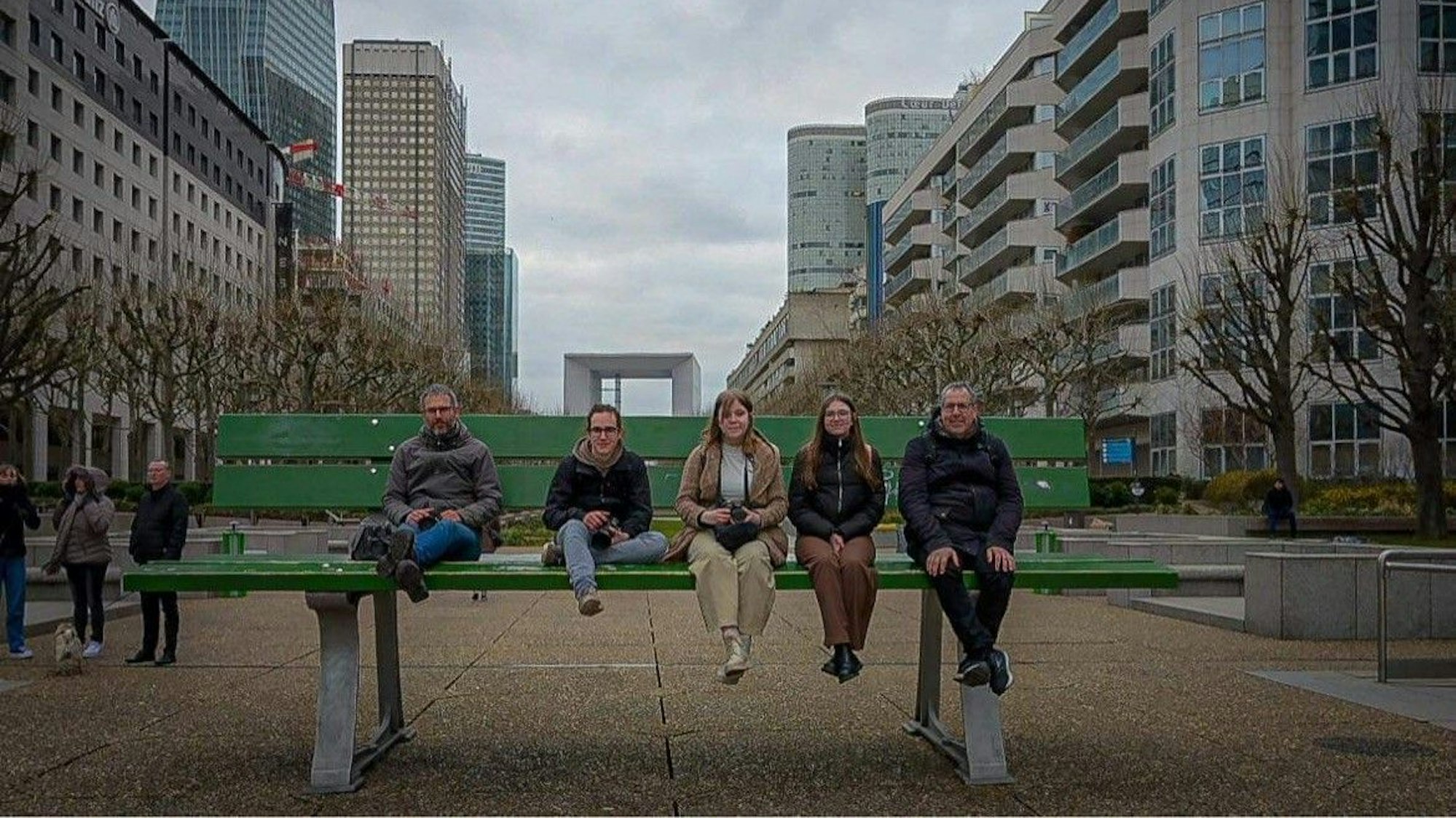 Das Bild zeigt Norbert Liebertz und weitere Hobbyfotografen auf einer grünen Bank in Paris.