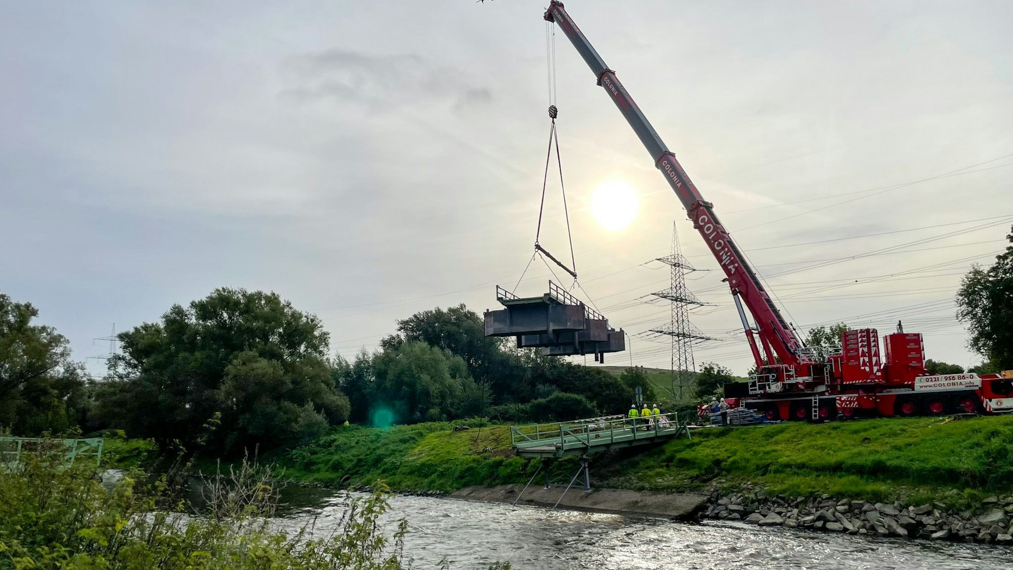 Ein Kran hebt einen Brückenteil heraus.