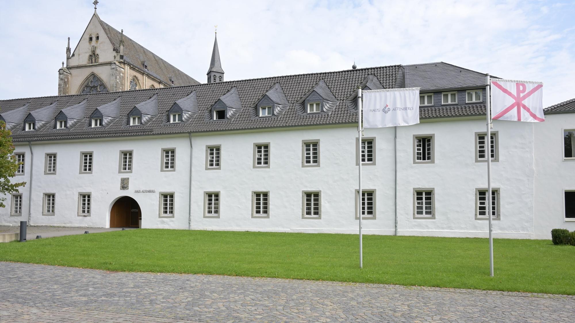 Die katholische Jugendbildungsstätte Haus Altenberg, davor zwei Fahnen.
