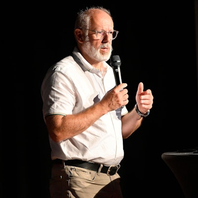 Zoodirektor Theo Pagel steht am Rednerpult mit einem Mikrofon in der Hand.