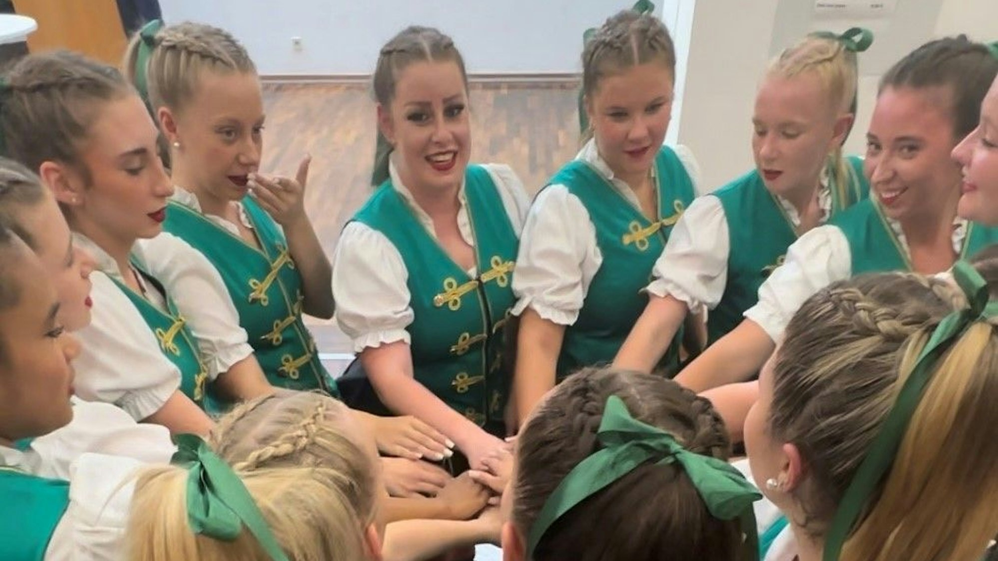 Das Foto zeigt die jungen Tänzerinnen der KG Treue Husaren, die sich vor einem Auftritt anfeuern.