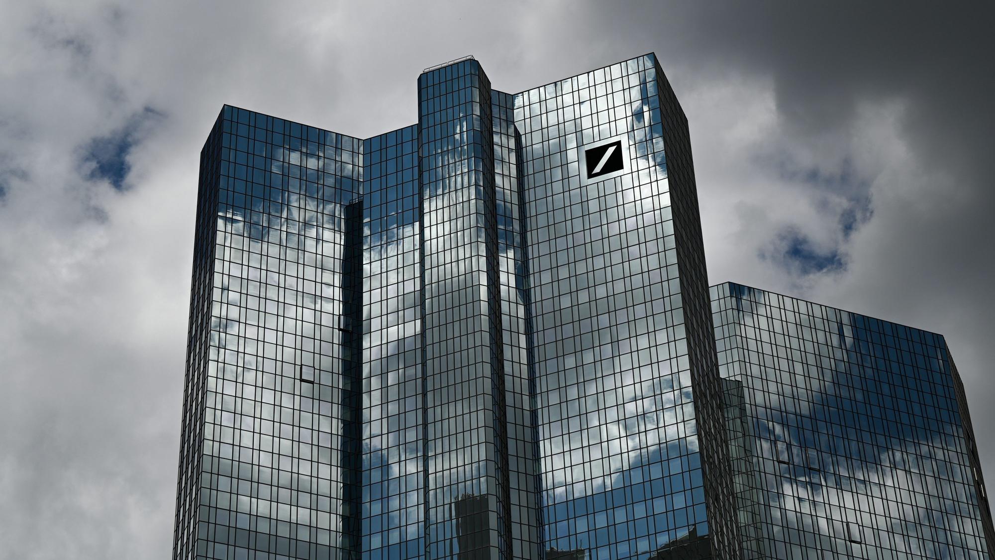 Hessen, Frankfurt/Main: Wolken ziehen über die Zentrale der Deutschen Bank, während sich der Wolkenhimmel in der Fassade spiegelt. (Symbolbild/Archivbild)