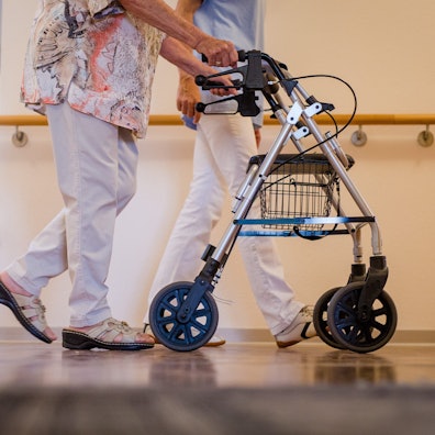 ARCHIV - 23.08.2018, Baden-Württemberg, Stuttgart: Eine Pflegekraft geht in einem Pflegeheim mit einer älteren Dame über einen Korridor. (zu dpa: «Teufelskreis - Wie Personalmangel Seniorenheimen die Luft abschnürt») Foto: Christoph Schmidt/dpa +++ dpa-Bildfunk +++