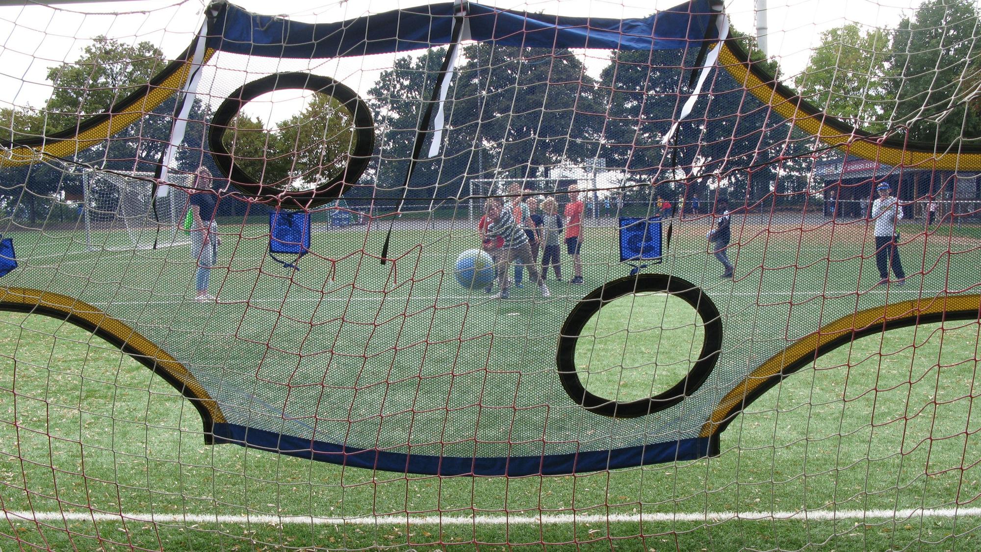 Ein Kind läuft bei der Feier zum Weltkindertag und 20. Geburtstag der Offenen Ganztagsschule auf dem Sportplatz an und schießt einen Ball in ein Tor.