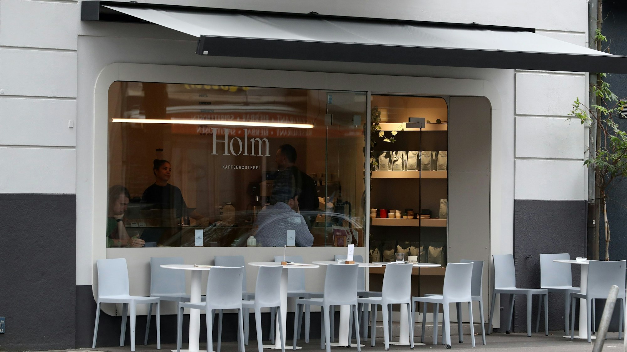 Das Café Holm von außen mit einem hellen Design.