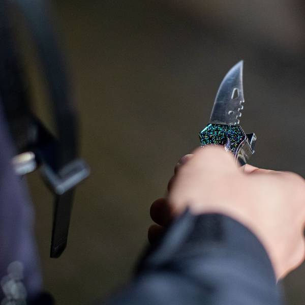 Ein Polizist hält ein sichergestelltes Messer in der Hand.