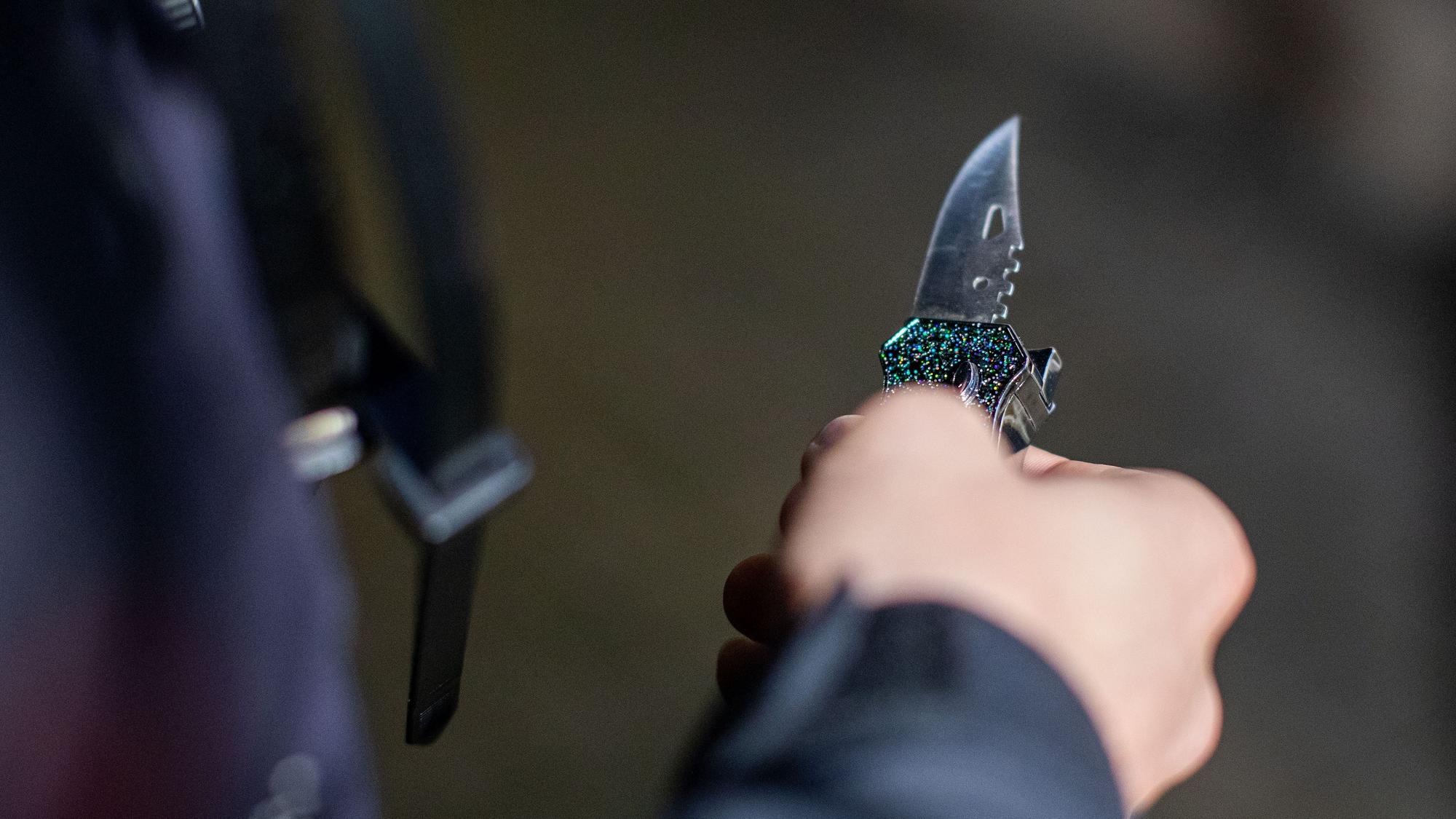 Ein Polizist hält ein sichergestelltes Messer in der Hand.