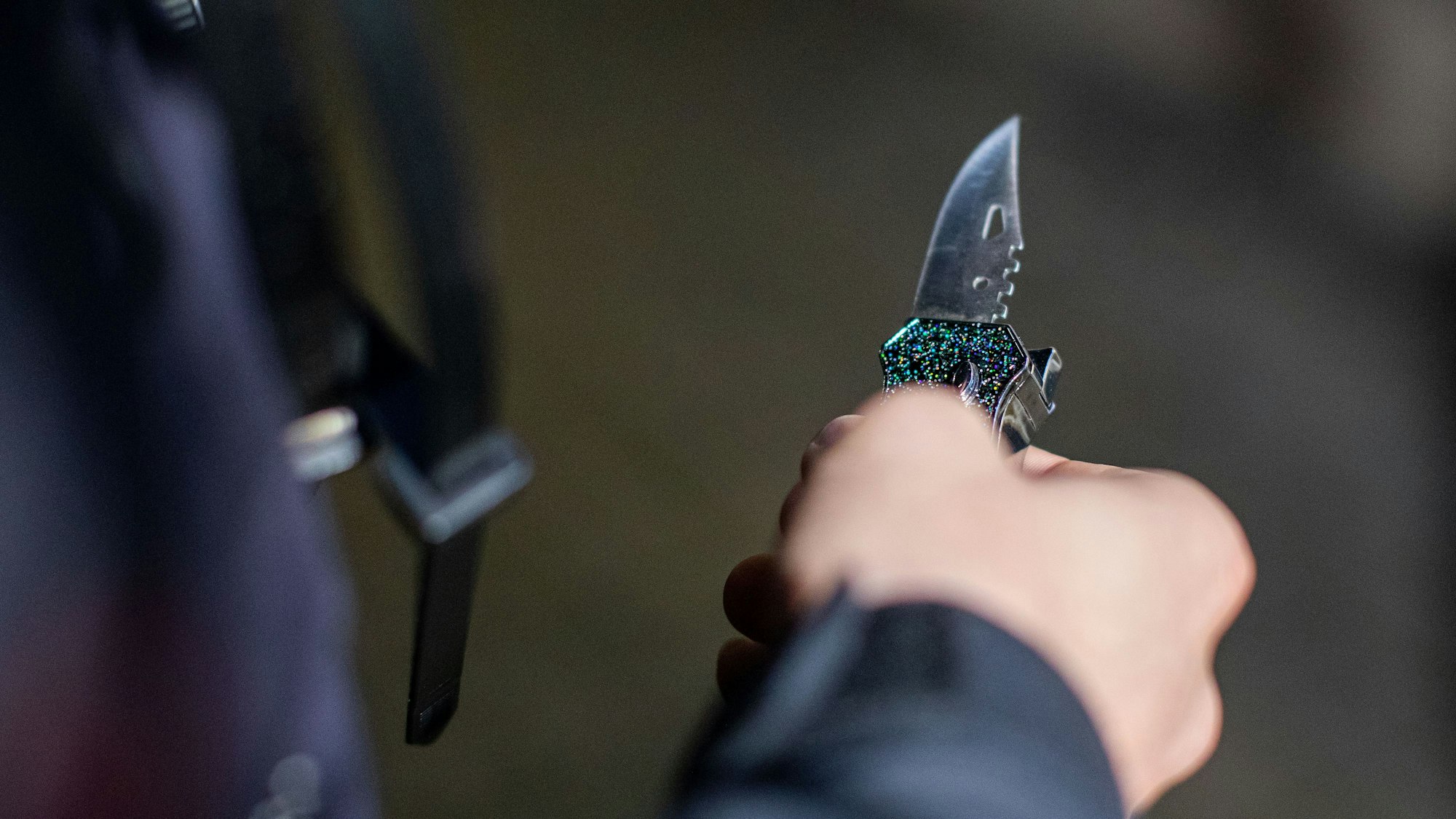 Ein Polizist hält ein sichergestelltes Messer in der Hand.