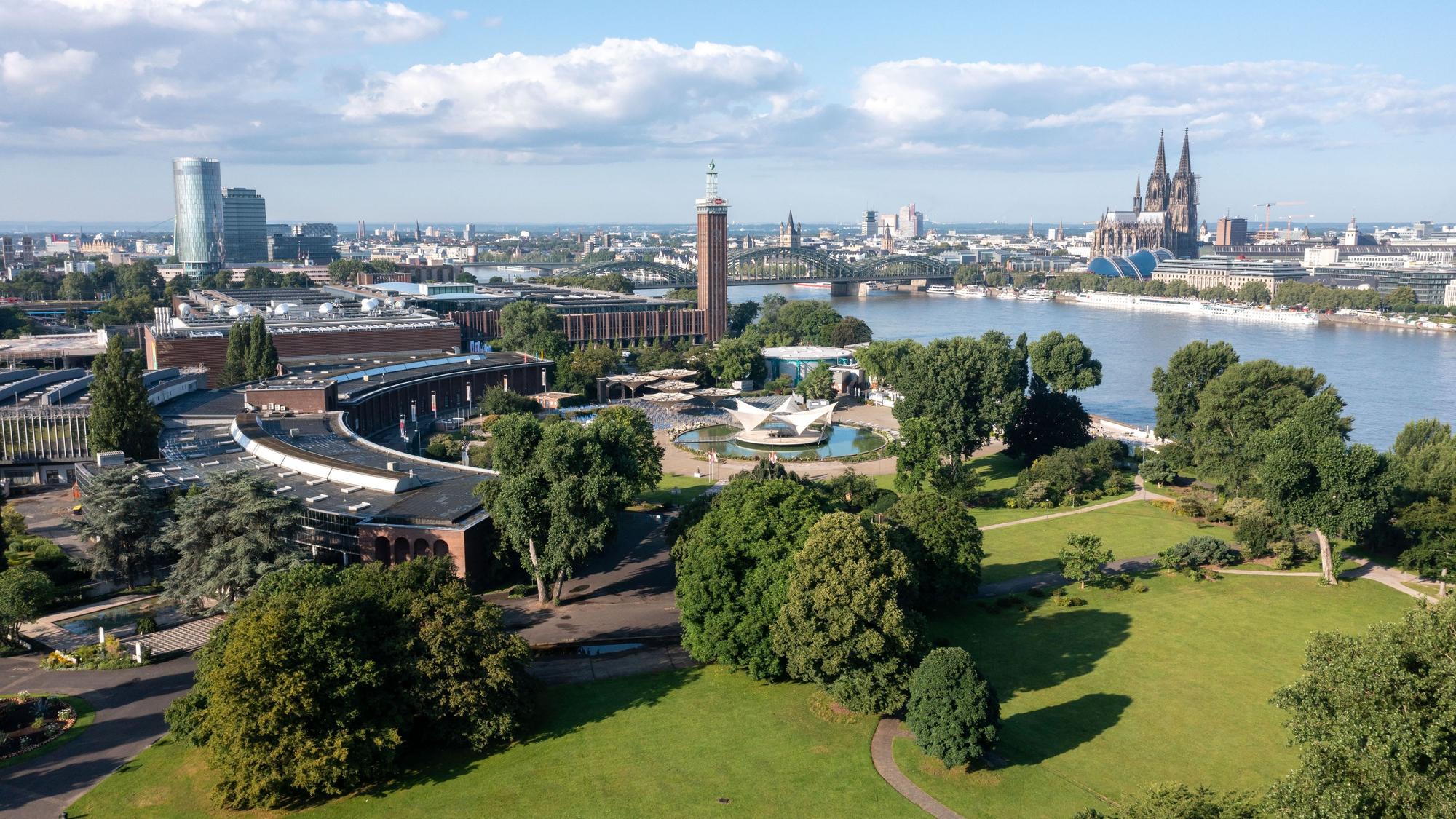 Das Bild zeigt den Rheinpark mit dem Tanzbrunnen und den alten Messehallen aus der Vogelperspektive.