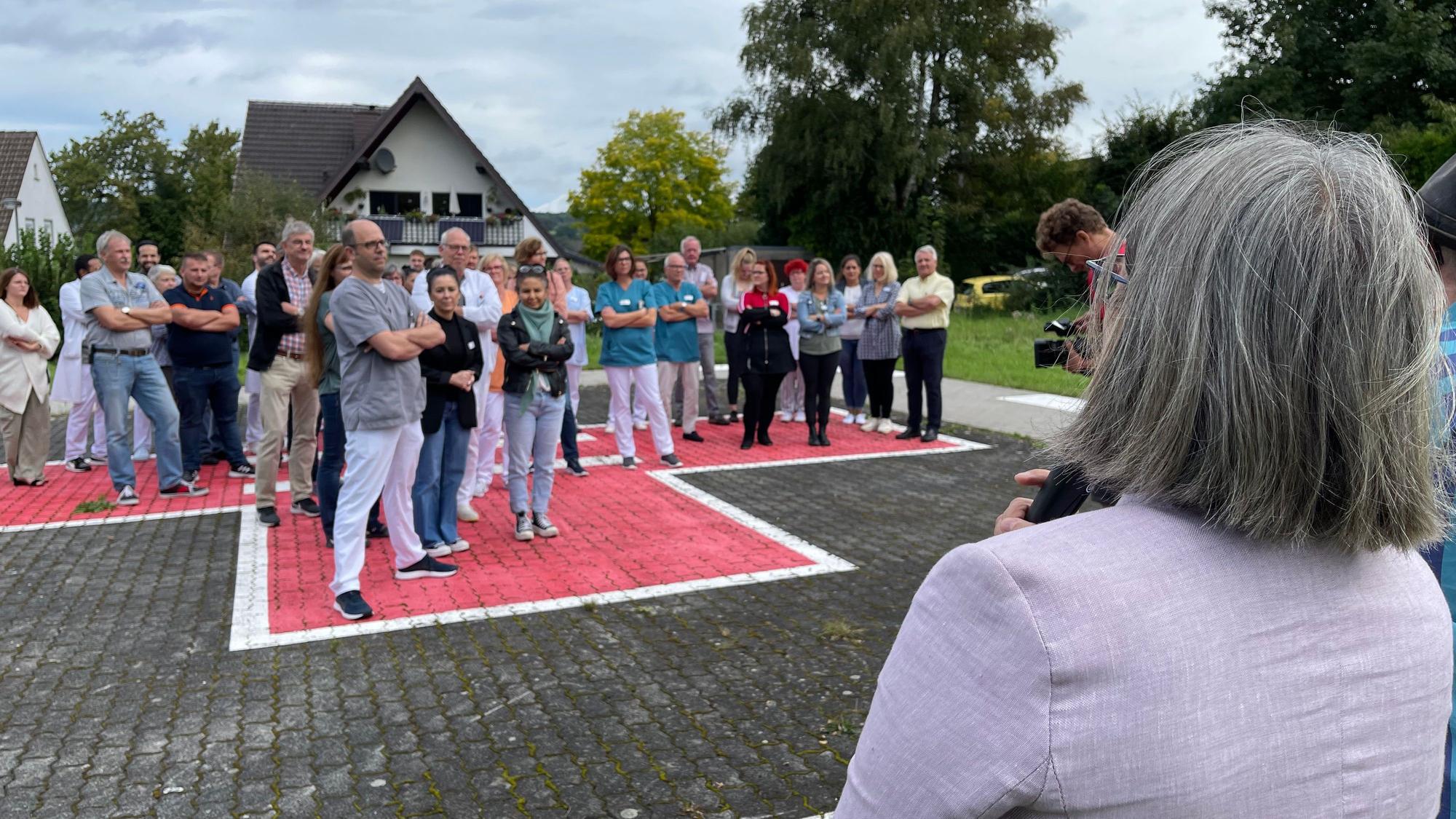 Eine Frau mit grauen Haaren steht am Mikrofon und spricht zu den Demonstranten.