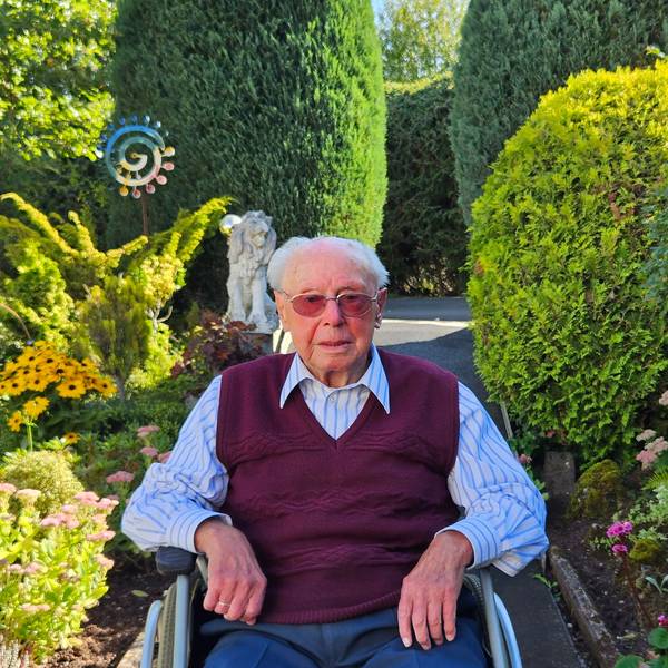 Emil Feyen sitzt in seinem Rollstuhl im Garten.