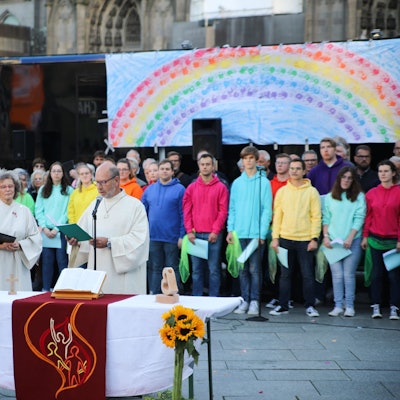 Pastoralreferent Manfred Becker-Irrnen während seiner Predigt beim Gottesdienst "Segen für alle" am Kölner Dom. Im Hintergrund der Jugendchors St. Stephan.