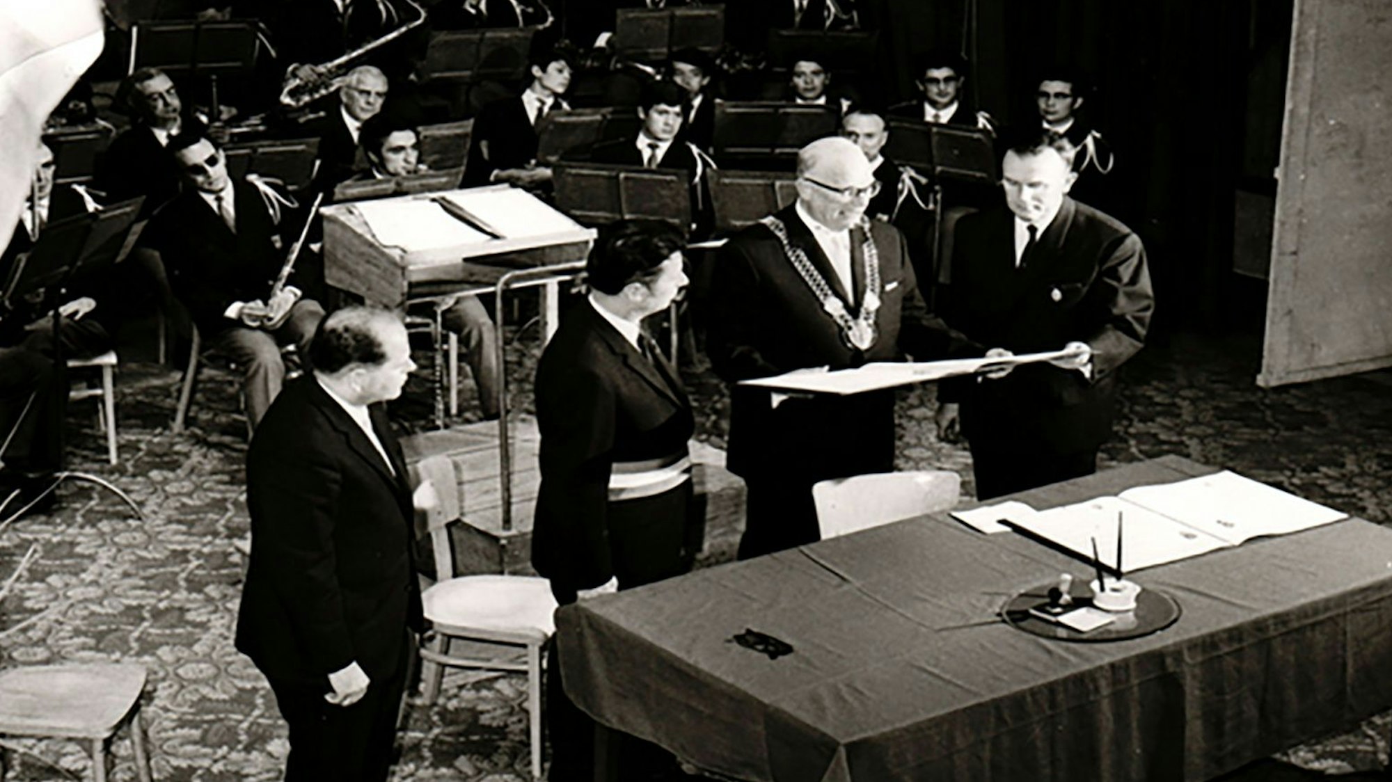 Eine alte Schwarz-Weiß-Aufnahme zeigt die Unterzeichnung der Partnerschaftsurkunde.