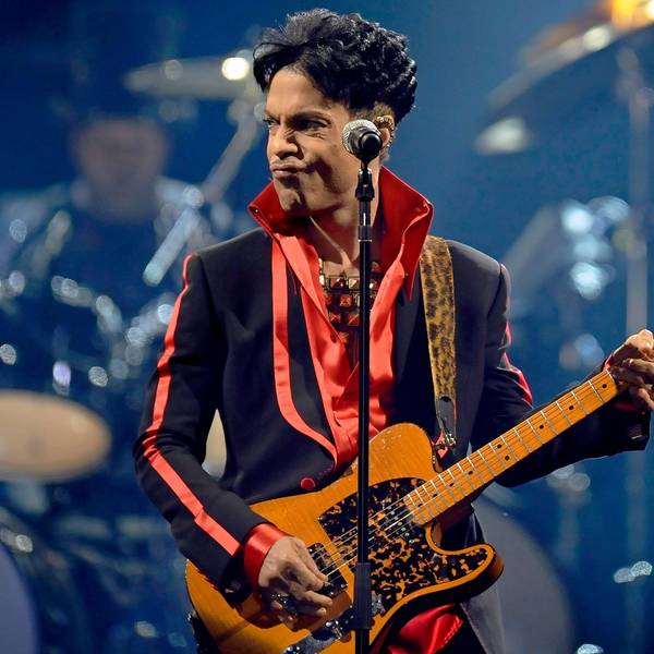 Prince spielt auf der Bühne Gitarre.