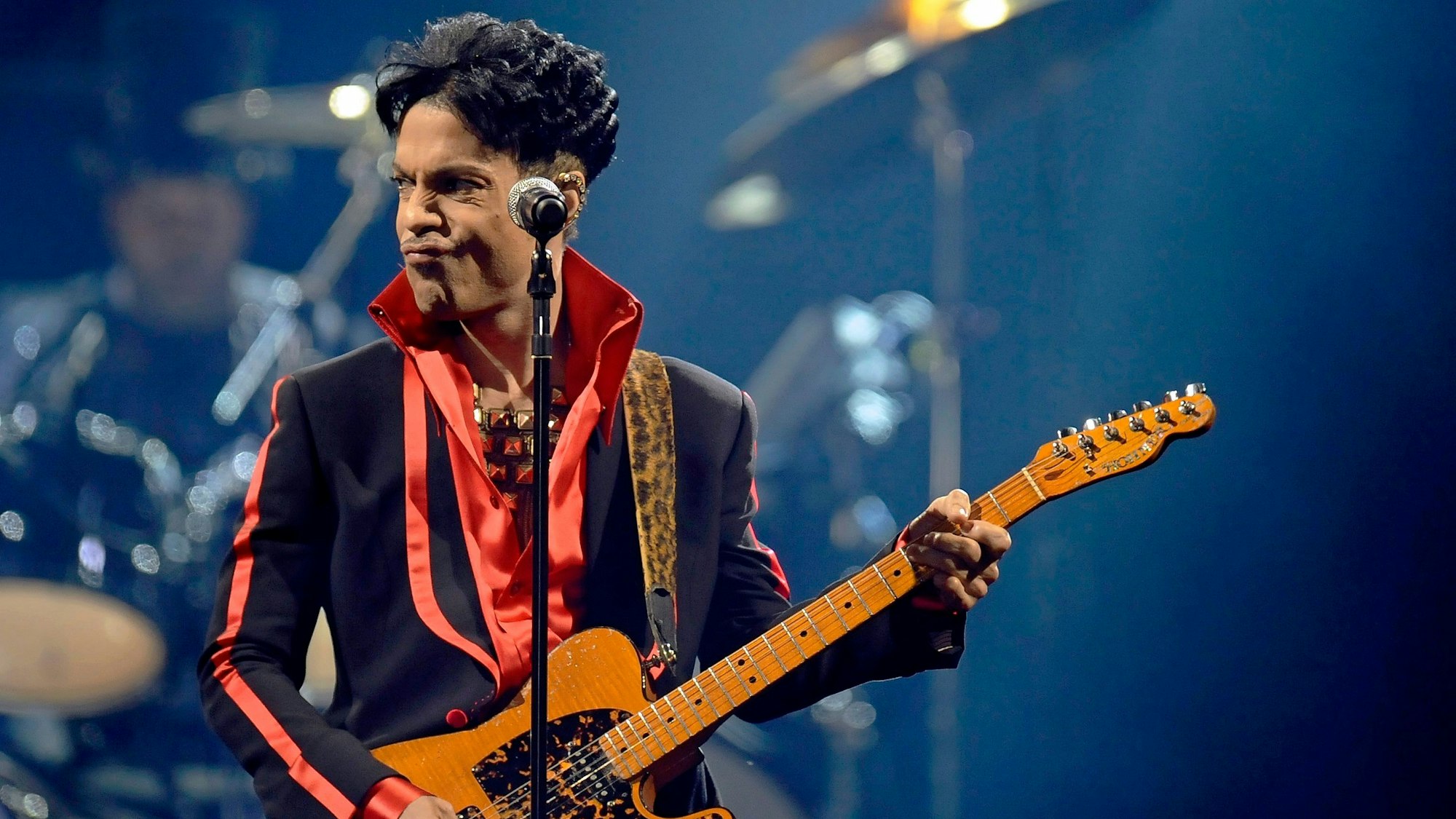 Prince spielt auf der Bühne Gitarre.