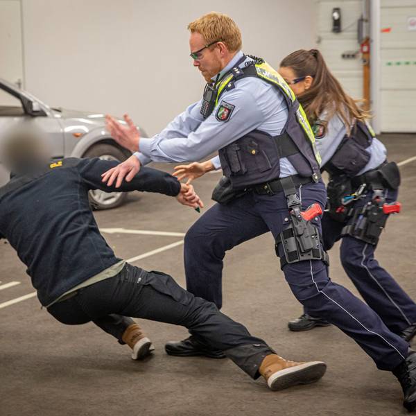 Polizeiübung: Ein unbekannter Mann greift zwei Uniformierte bei einer Standard-Kontrolle mit einer Stichwaffe an. Zwei Beamte wehren einen Angriff ab, der Statist geht zu Boden.