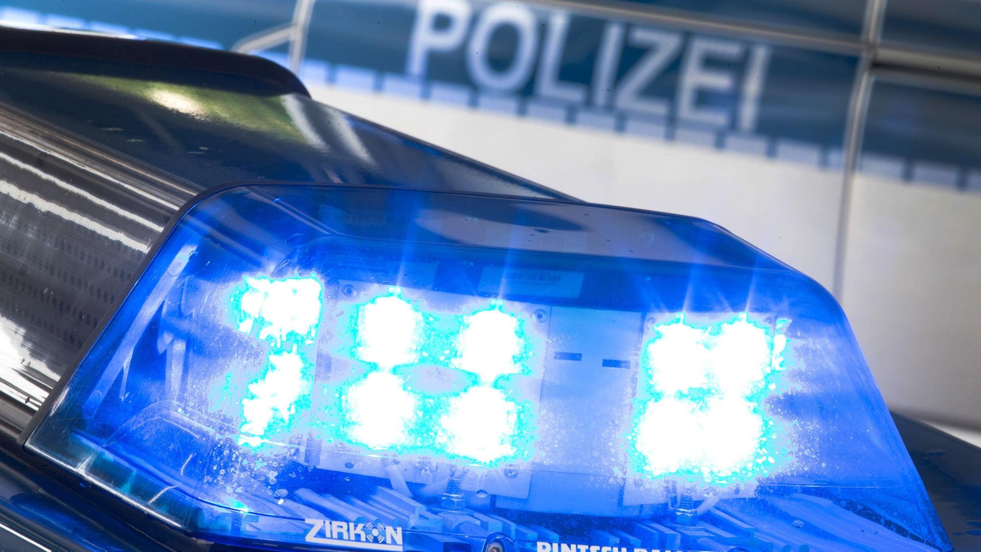 Ein Blaulicht leuchtet während eines Einsatzes auf dem Dach eines Polizeiwagens.