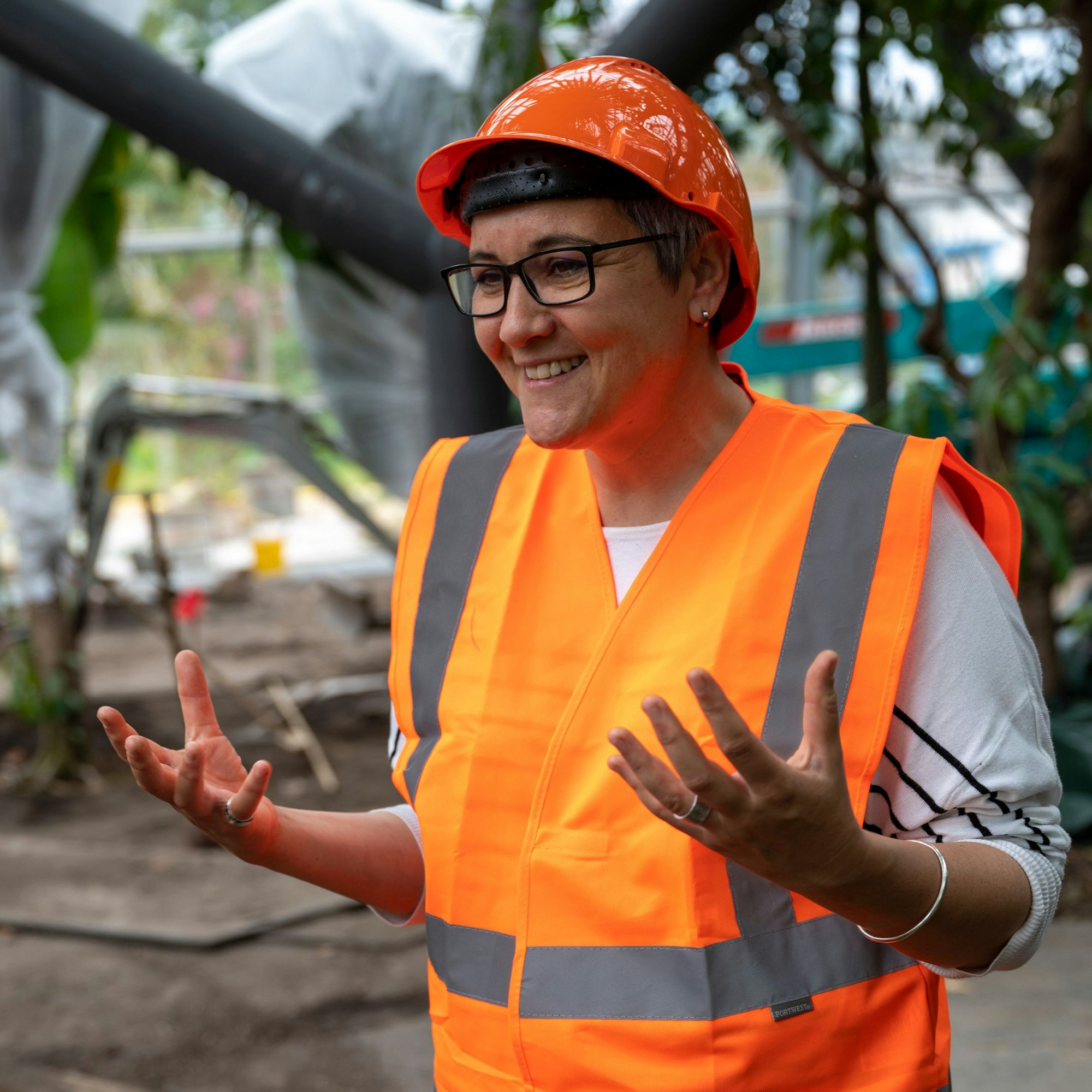 Marina Tsaliki trägt einen Schutzhelm, weil in den Schaugewächshäusern noch die letzten Konstruktionsarbeiten laufen.