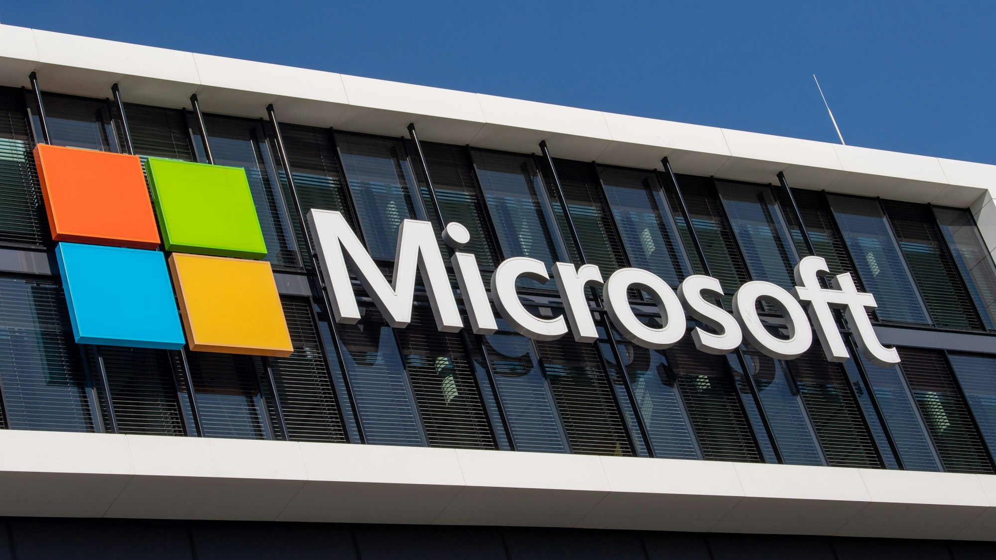 Das Microsoft Logo hängt an der Fassade eines Bürogebäudes. (Archivbild)