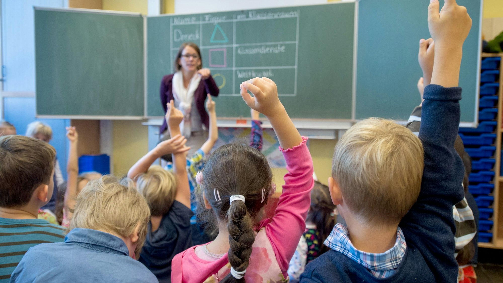 Kinder sitzen in einer ersten Klasse.