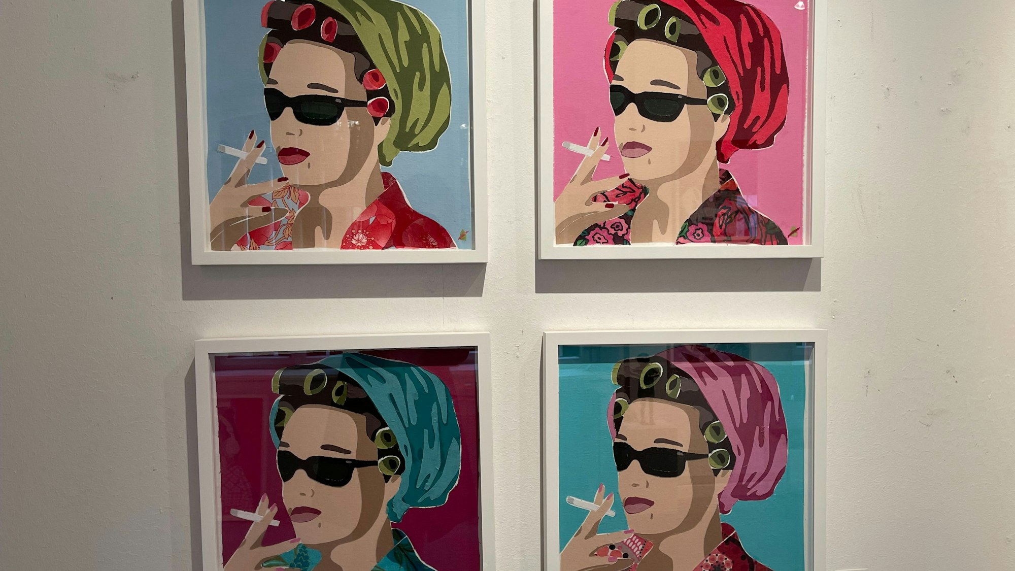 Vier poppig-bunte Bilder einer rauchenden Frau mit Lockenwicklern unter einem Kopftuch.