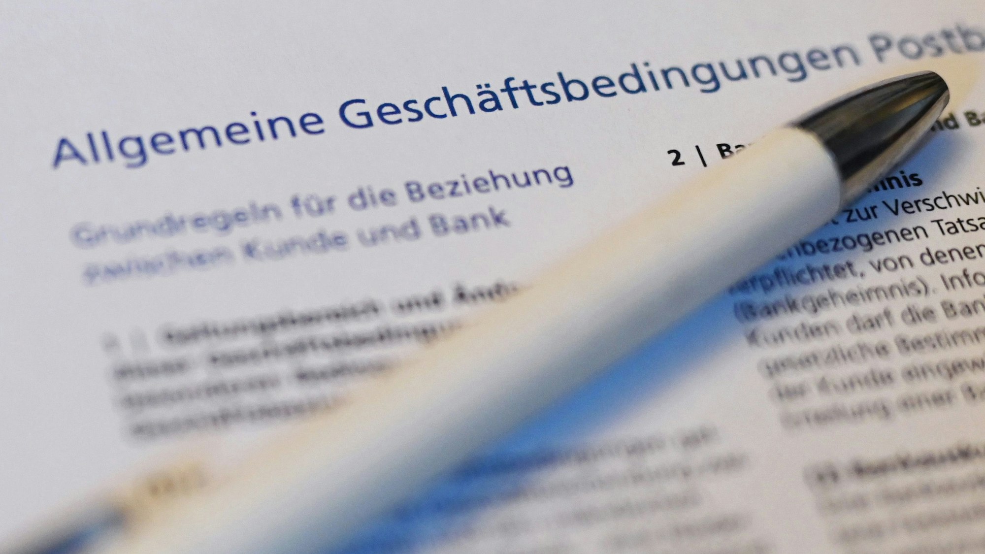 Ein Kugelschreiber liegt auf der ersten Seite der Allgemeine Geschäftsbedingungen (AGB) der Postbank.