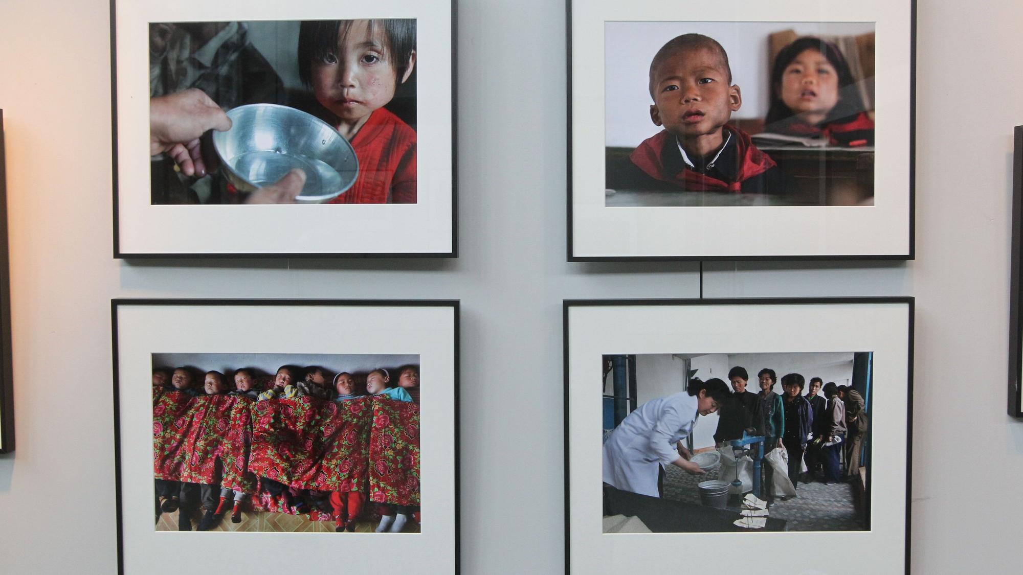An einer Wand hängen vier Fotografien von Kindern aus Nordkorea.