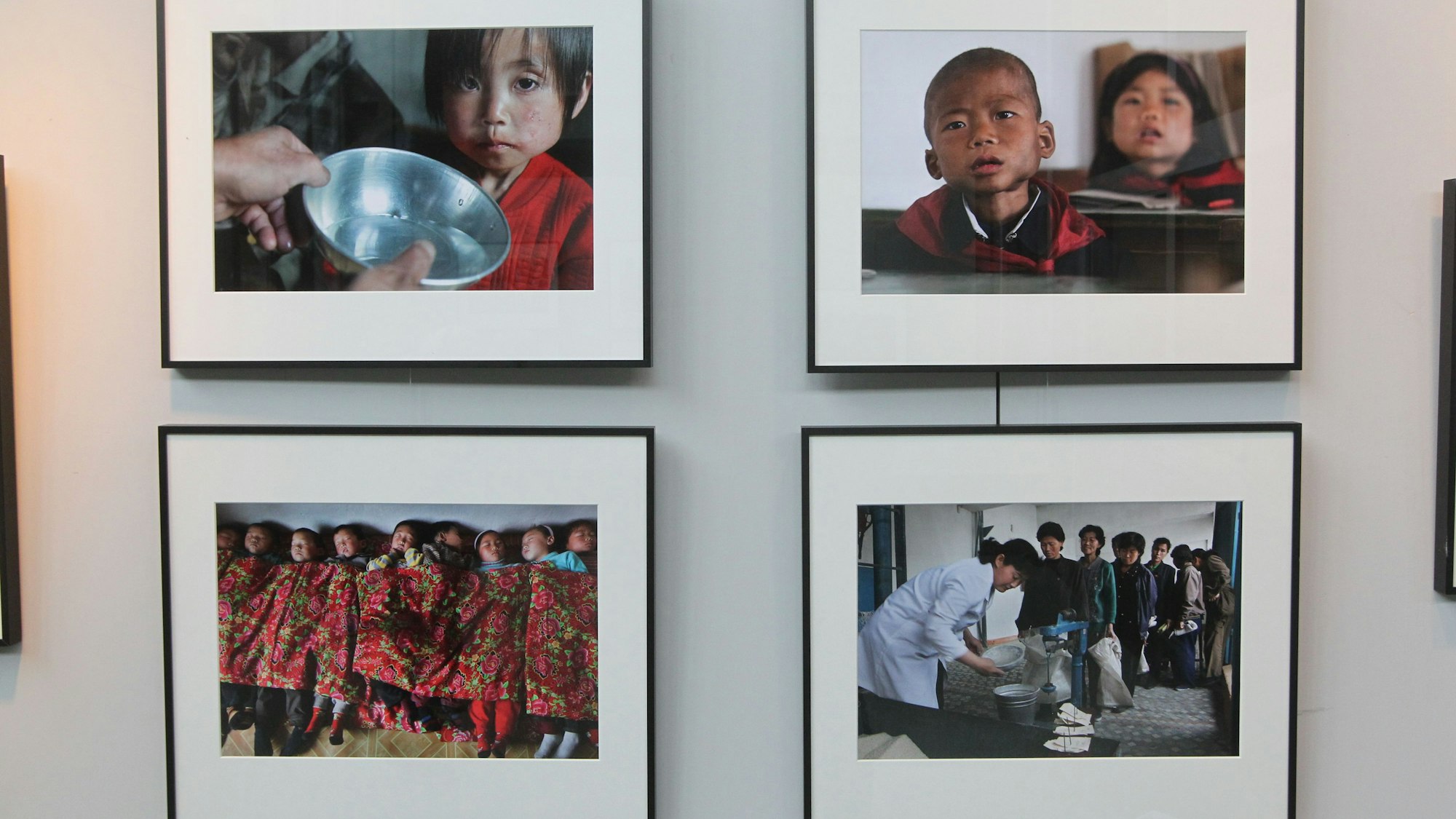 An einer Wand hängen vier Fotografien von Kindern aus Nordkorea.