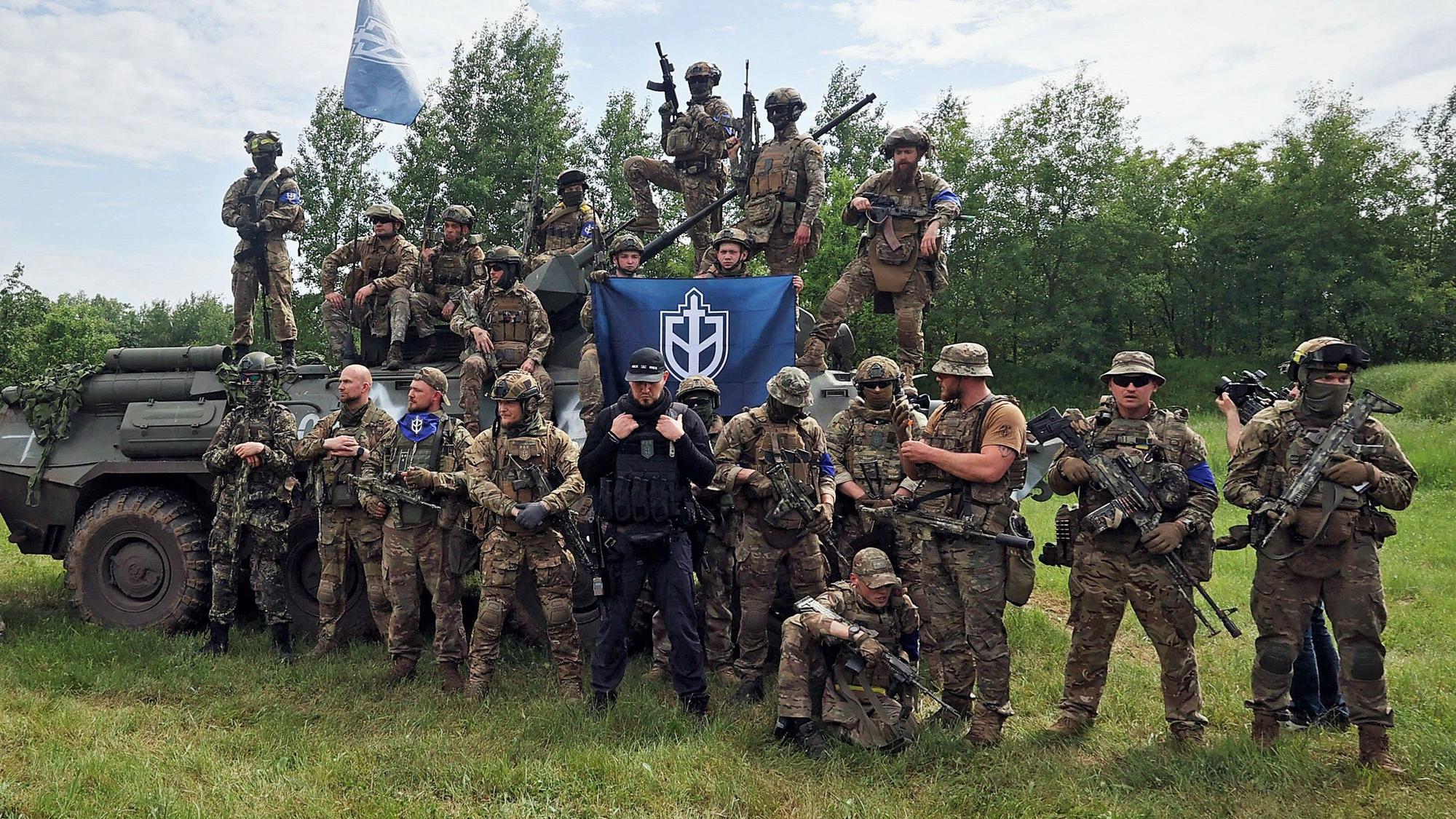 Der russische Neonazi Denis Nikitin (M., schwarze Kleidung) im Gespräch mit Pressevertretern. Im „Guardian“ hat er sich nun zu den Einsätzen seines „Russischen Freiwilligenkorps“ in russischen Grenzregionen geäußert.