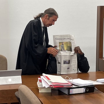 Der Angeklagte versteckt sich hinter der Zeitung seines Verteidigers Ingo Lindemann.