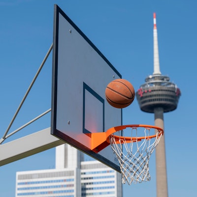 Ein Basketballnetz im Grüngürtel, im Hintergrund der Colonius