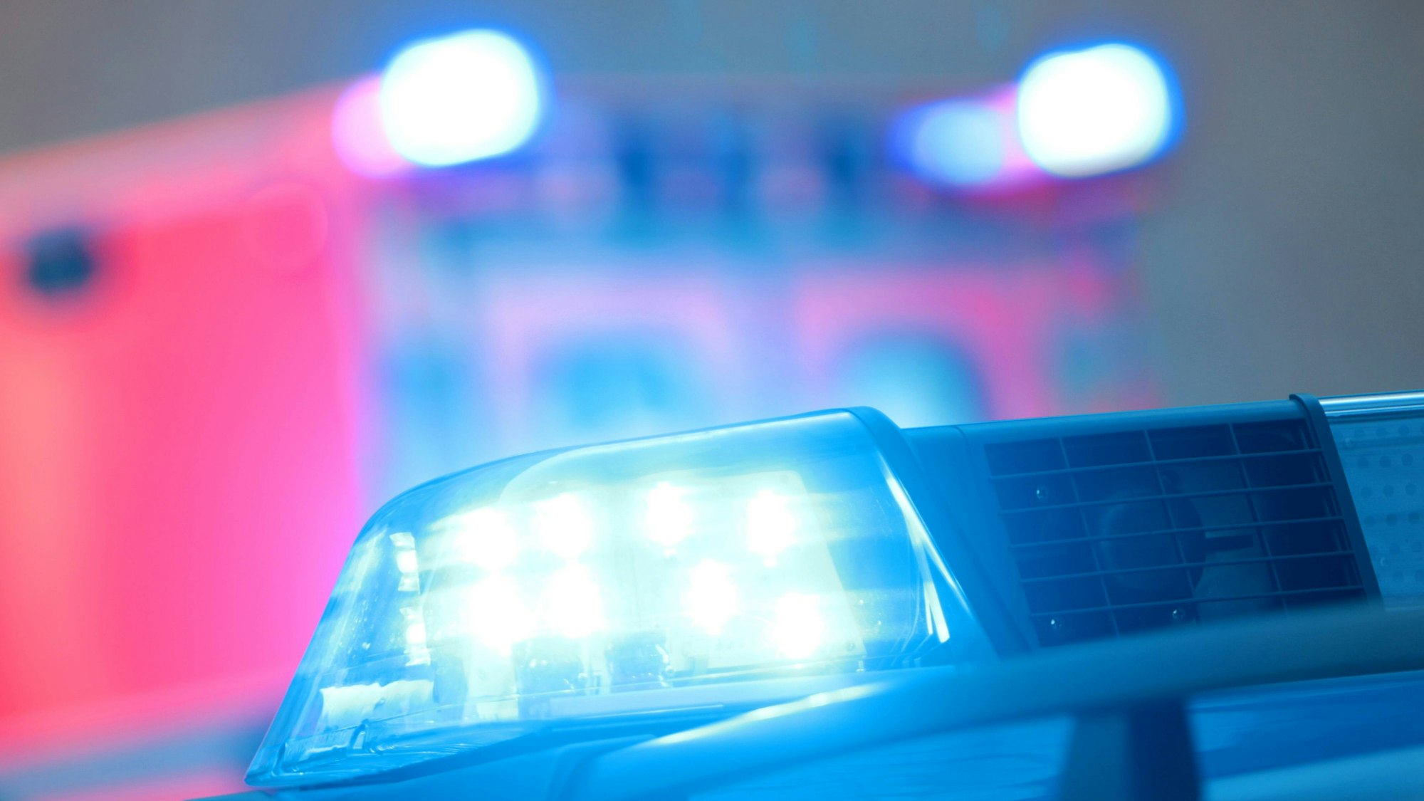 Einsatzwagen der Polizei mit eingeschaltetem Blaulicht und Notarzt Rettungswagen bei einem Einsatz in der Innenstadt Köln an Silvester, Nordrhein Westfalen, Deutschland