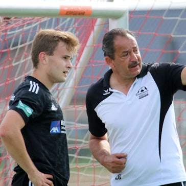 Ein Fußballtrainer gibt seinem Spieler Anweisungen.