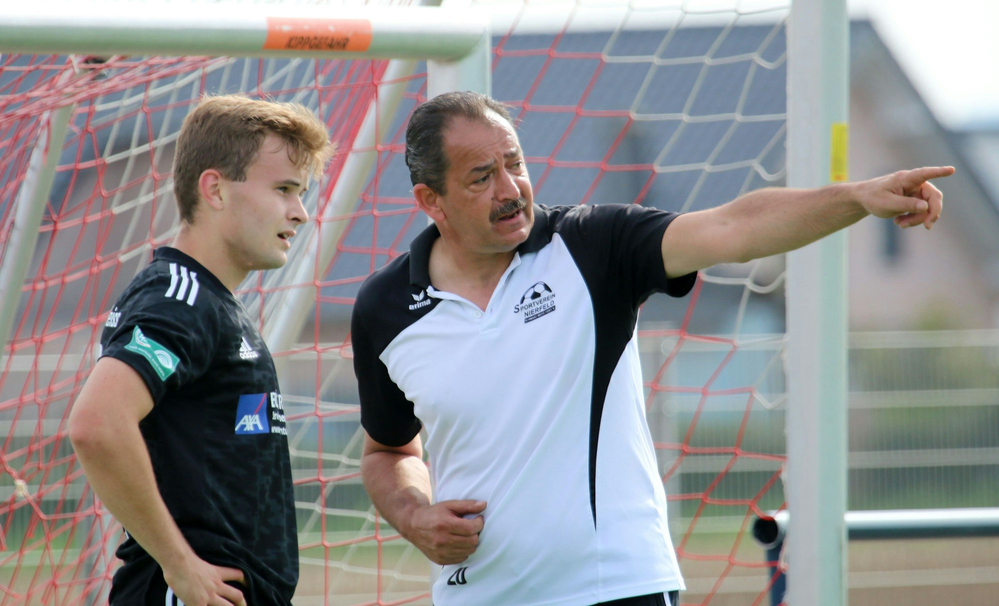 Ein Fußballtrainer gibt seinem Spieler Anweisungen.