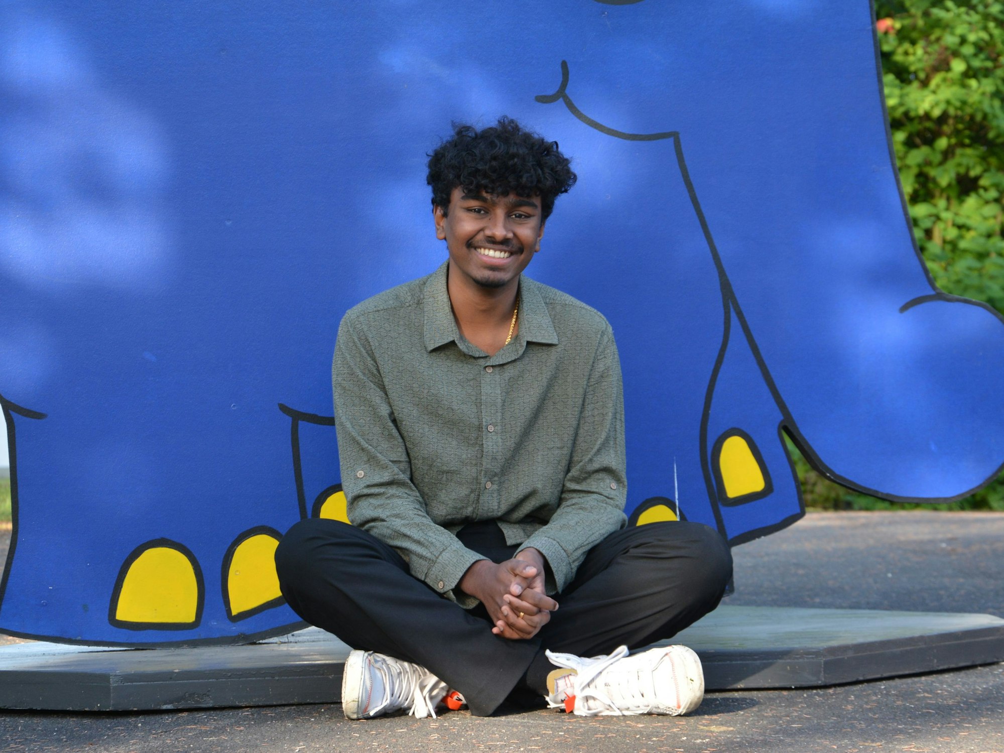 Rohit Narayanan sitzt vor einer Figur des Elefanten.