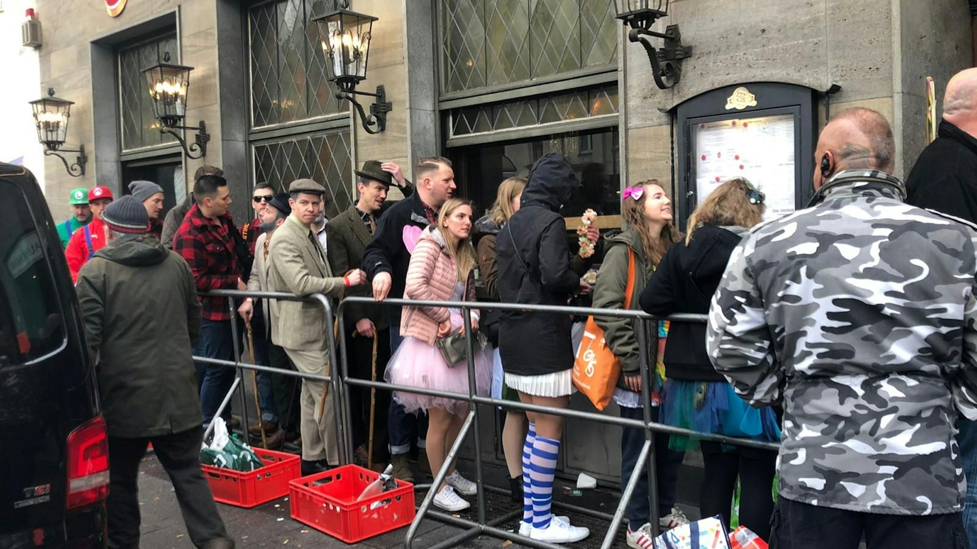 Warteschlangen vor dem Haus Unkelbach in Sülz, vor der Kneipe stehen Absperrgitter.