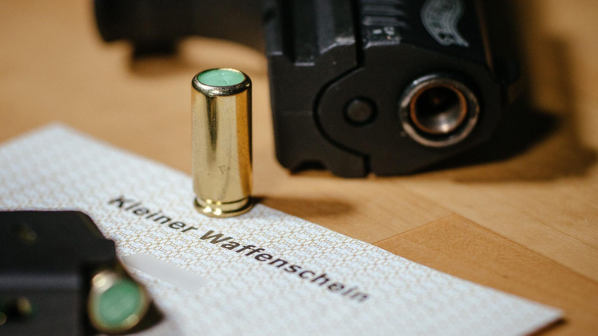 Ein kleiner Waffenschein liegt zwischen einer Schreckschuss-Pistole «Walther P22», einem Magazin und einer Platzpatrone.