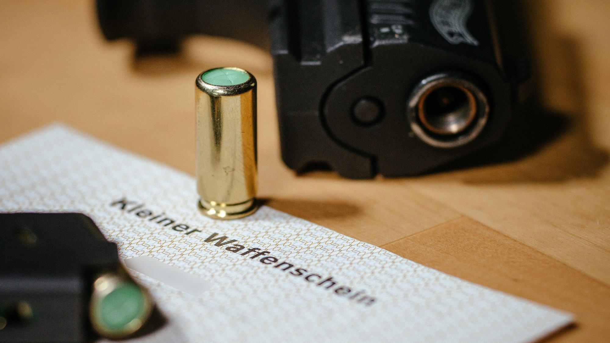 Ein kleiner Waffenschein liegt zwischen einer Schreckschuss-Pistole «Walther P22», einem Magazin und einer Platzpatrone.